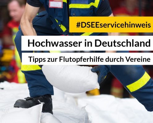 Feuerwehrmann reicht Sandsack weiter. Aufschrift: #DSEEservicehinweis Hochwasserkatastrophe. Unterstützung vor Ort