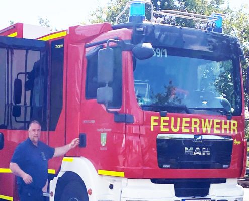 Feuerwehrmann vor einem Einsatzfahrzeug der Feuerwehr Panketal