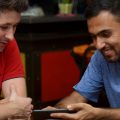 zwei junge Männer lächelnd mit Smartphone