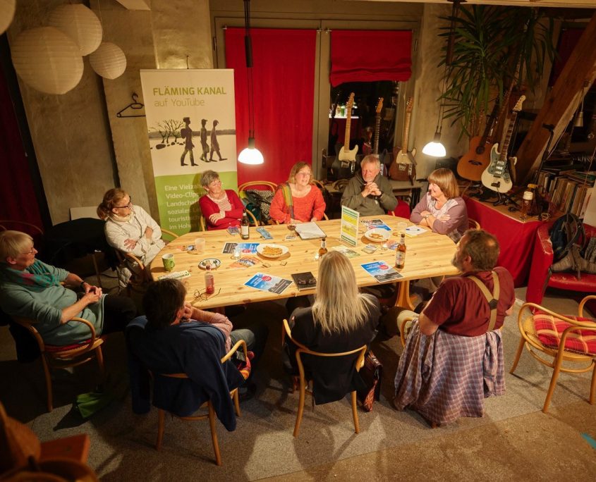 Mehrere Menschen sitzen gemütlich an einem Tisch