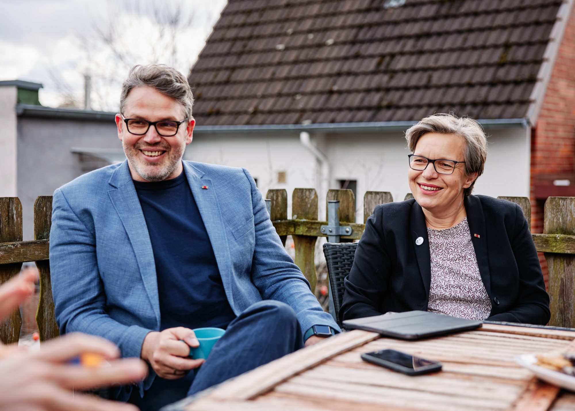 Ein Mann und eine Frau sitzen lachend an einem Tisch.