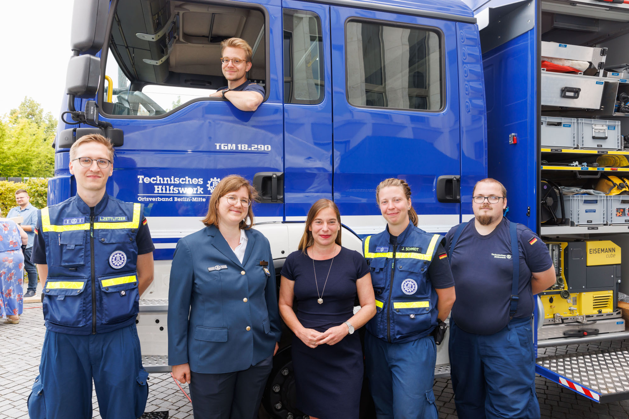 Gruppenfoto beim Tag der offenen Tür der Bundesregierung von THW-Engagierten mit DSEE-Vorständin Katarina Peranić von einem THW-Einsatzfahrzeug