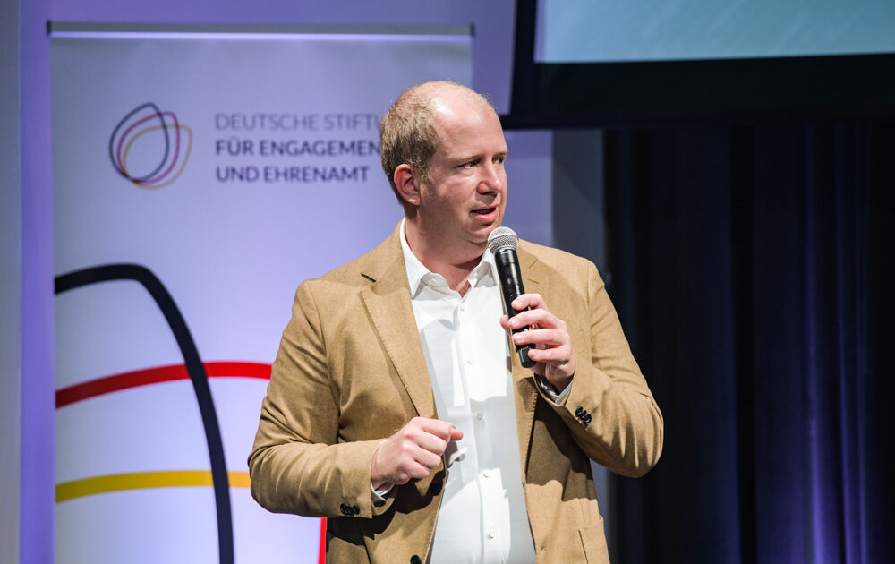 DSEE-Vorstand Jan Holze begrüßt die Gäste des DSEE Science Slams im Silent Green, Berlin