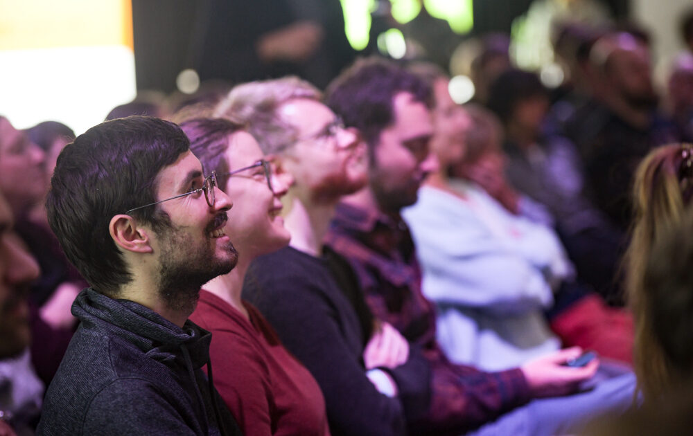 Lachende Zuschauerinnen und Zuschauer beim DSEE Science Slam im Silent Green, Berlin