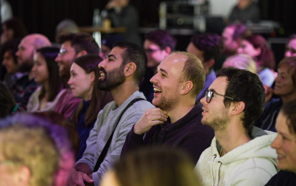 Lachende Zuschauerinnen und Zuschauer beim DSEE Science Slam 2022 in Berlin