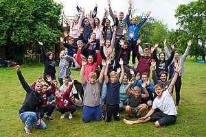 Gruppenfoto von Jugendlichen mit hochgerissenen Armen