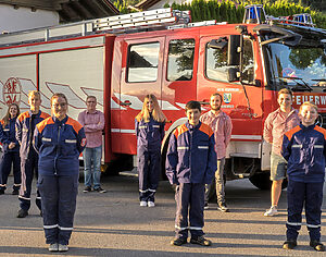 neun Jugendliche vor einem Feuerwehrauto