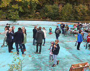 vielen Menschen aus allen Generationen auf einem baufälligen Freizeitparkgelände