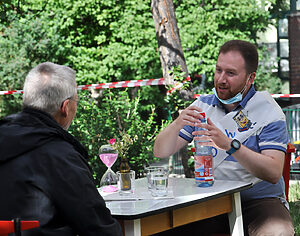 Ein jüngerer und ein älterer Mann am Tisch im Gespräch