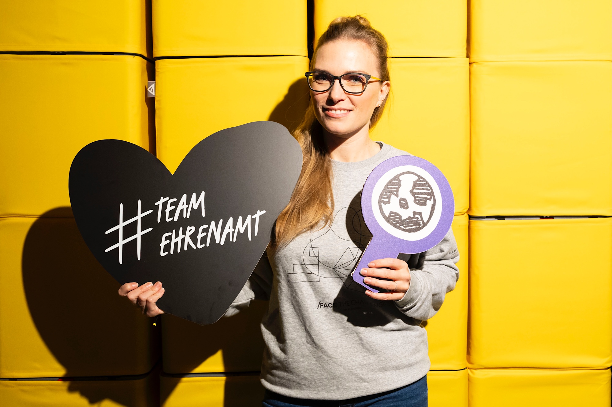 Tatjana Kiel hält ein Herz mit der Aufschrift #Team Ehrenamt