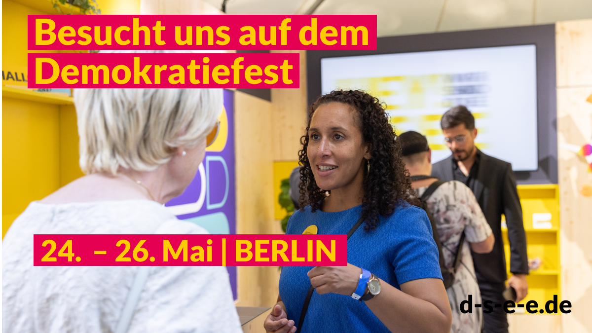 Foto mit Menschen, die sich am DSEE-Stand unterhalten. Text: Besucht uns auf dem Demokratiefest. 24. – 26. Mai | Berlin d-s-e-e.de