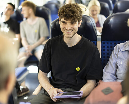 Ein junger Mann lächelt in der Metro sein Gegenüber an