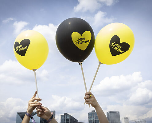 zwei gelbe und ein schwarzer Lufballon mit der Beschriftung "# Team Ehrenamt" (zusammengeschrieben)